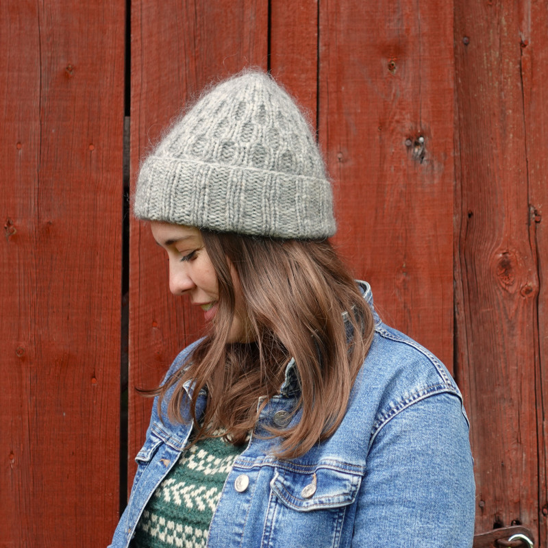A fluffy and warm grey knit beanie with a brim and beautiful cable pattern.